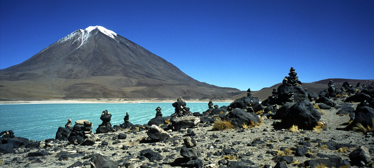 chi_7_30 licancabur pano.jpg - Sud Lipez volcan Licancabur de nombreux cairns ont été édifiés par les passants successifs avec les roches volcaniques au bord de la laguna Verde